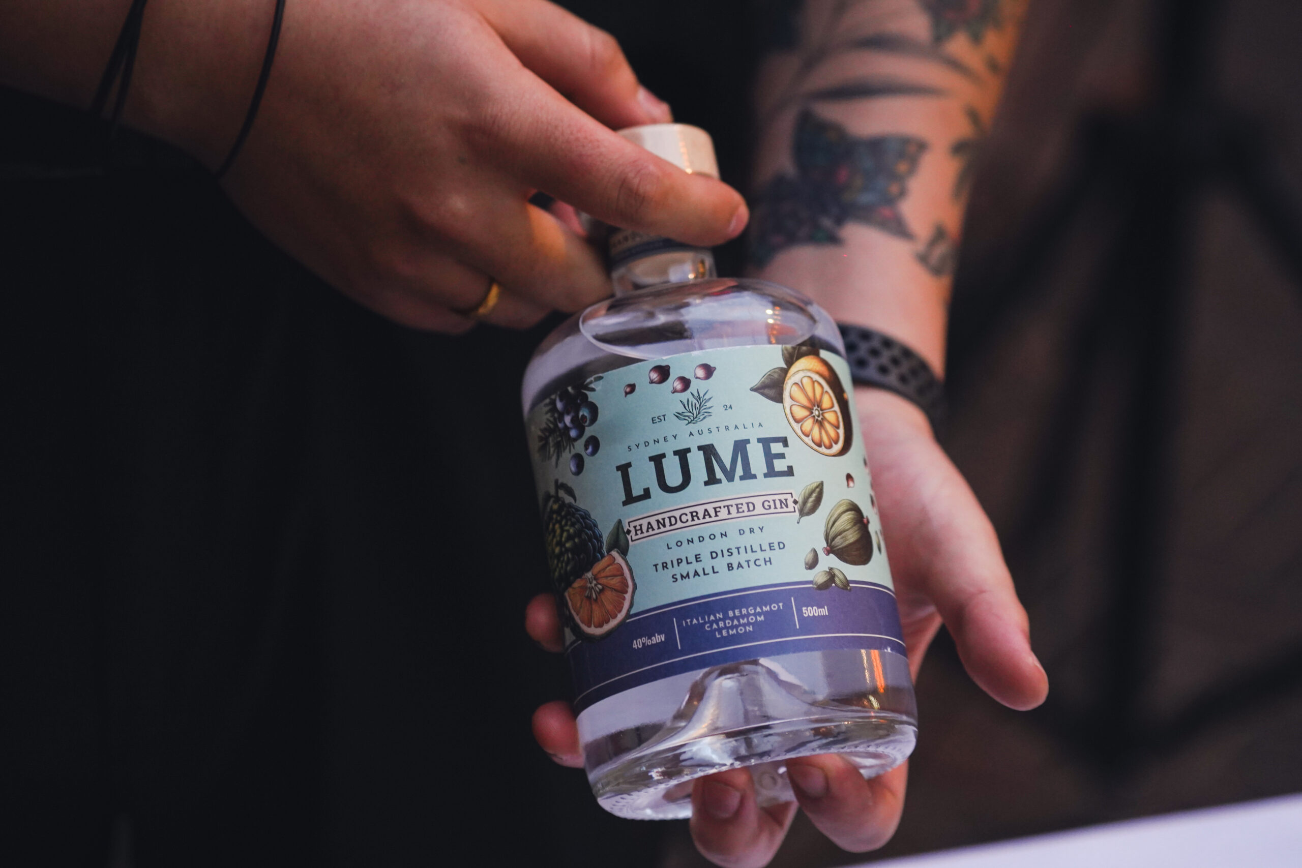 Hand holding Lume Handcrafted Gin bottle